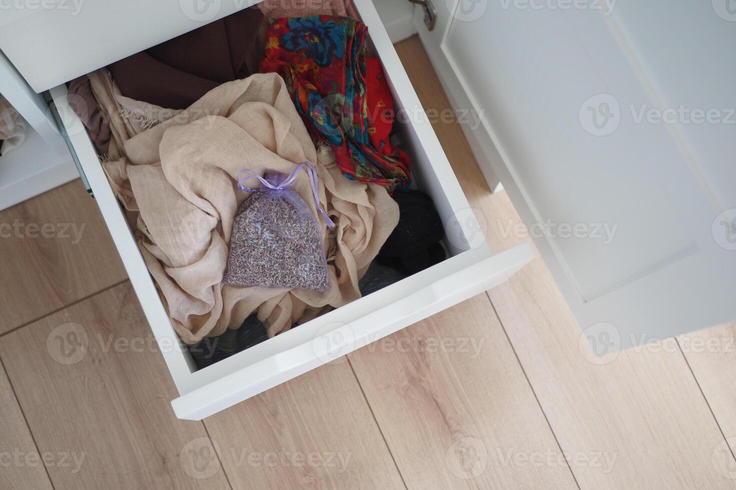 Colorful fabrics and lavender sachet in a white drawer photo