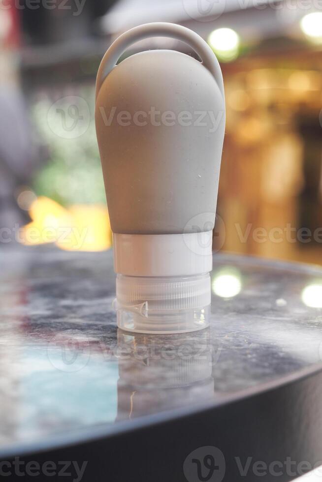 Soft travel bottle standing on a shiny table surface photo
