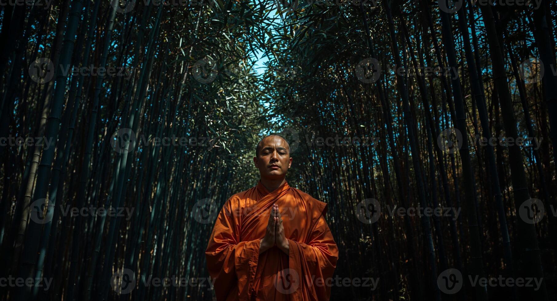 A monk in an orange robe standing in the middle of a bamboo forest photo