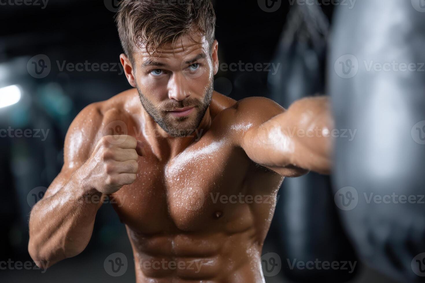 Intense boxing training session with a muscular athlete in a gym photo