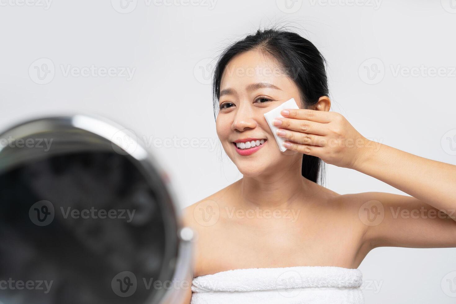 Attractive beauty young asian woman clean skin with cotton pad removing make up on white background. photo