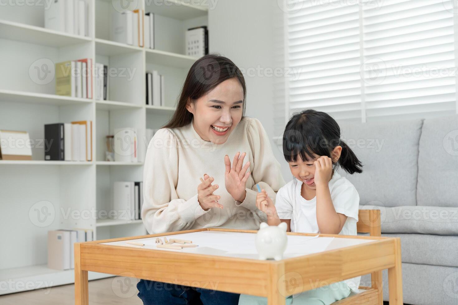 mother encourage for little girl after drawing success. Funny family is happy and excited in the house. Mother and daughter having fun spending time together. Holiday, Activity photo