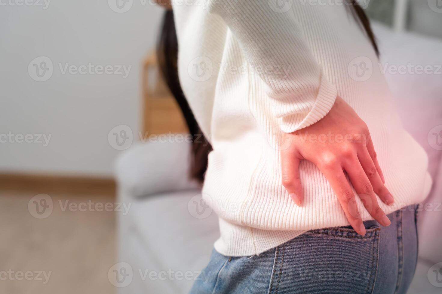 woman holding lower back while and suffer from unbearable pain health and problems, chronic back pain, backache in office syndrome, scoliosis, herniated disc, muscle inflammation. photo