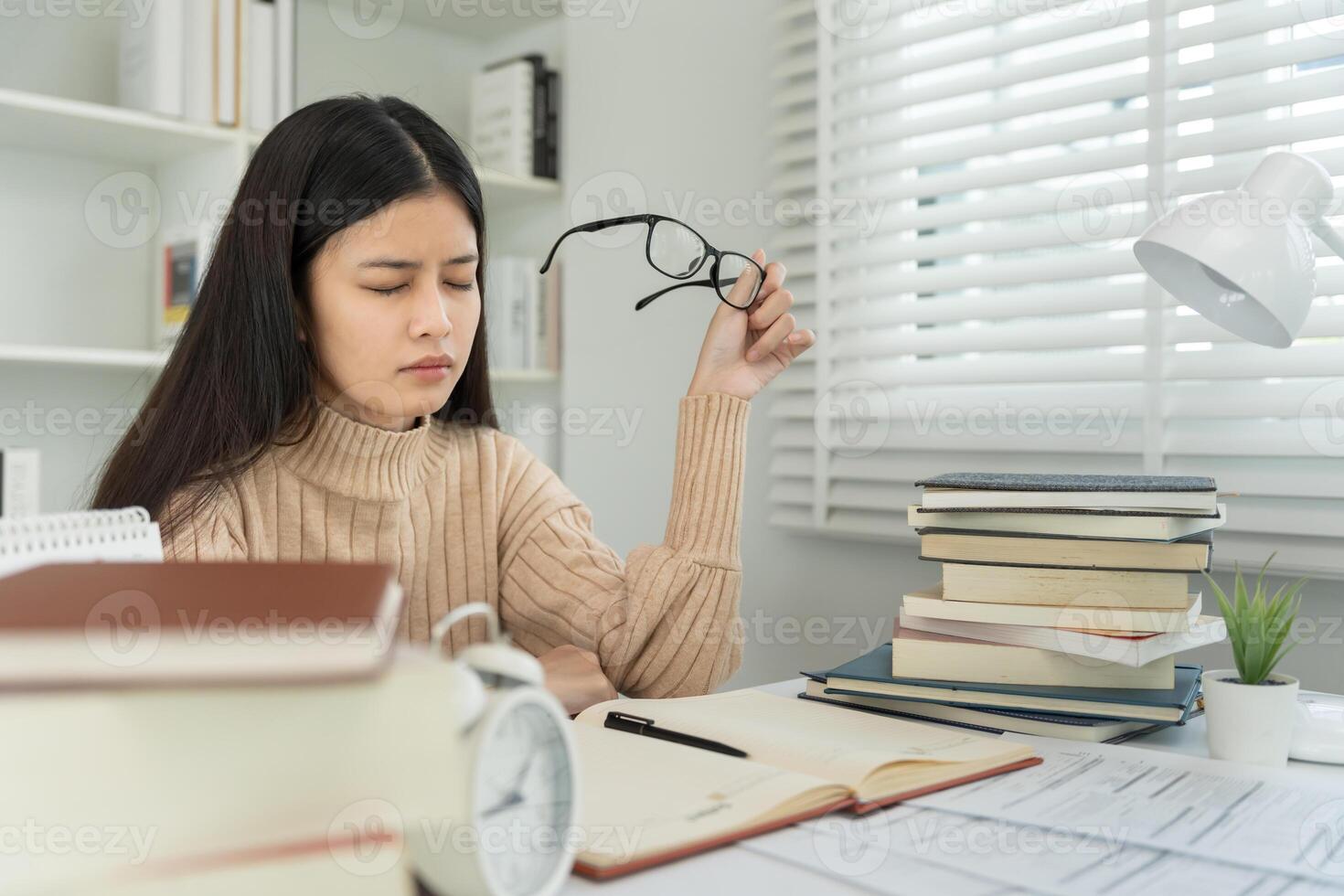 Eye problems, Asian women with tired and irritated eyes, eye rubbing, dry, eye pain after work, migraine, headache, blurred vision, photophobia, eye hurt from Read a book for a long time. photo