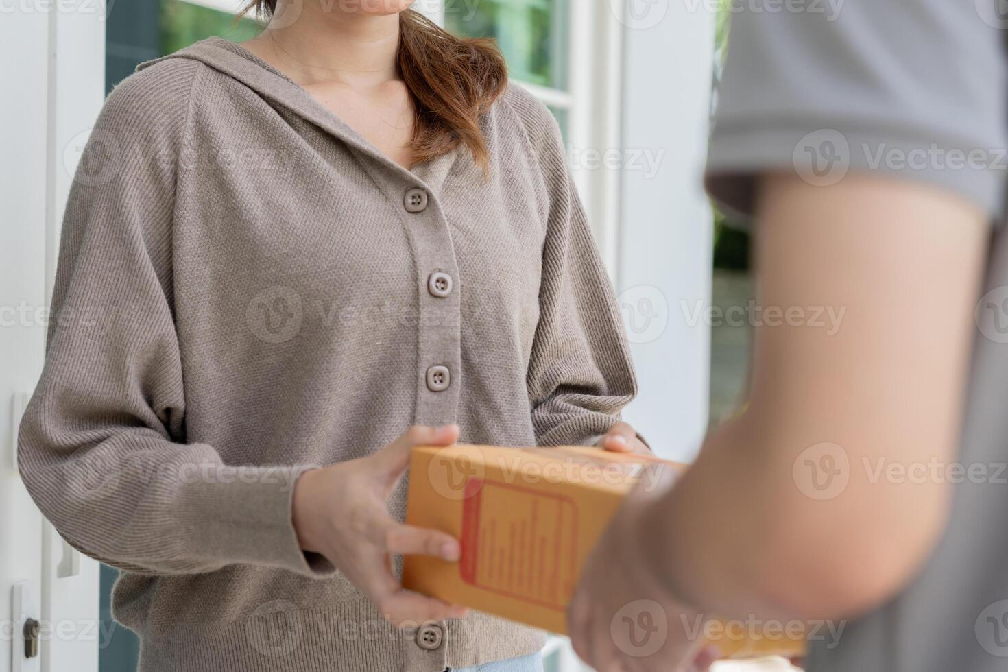 woman receives boxes parcel from courier in front house. Delivery man send deliver express. online shopping, paper containers, takeaway, postman, delivery service. photo