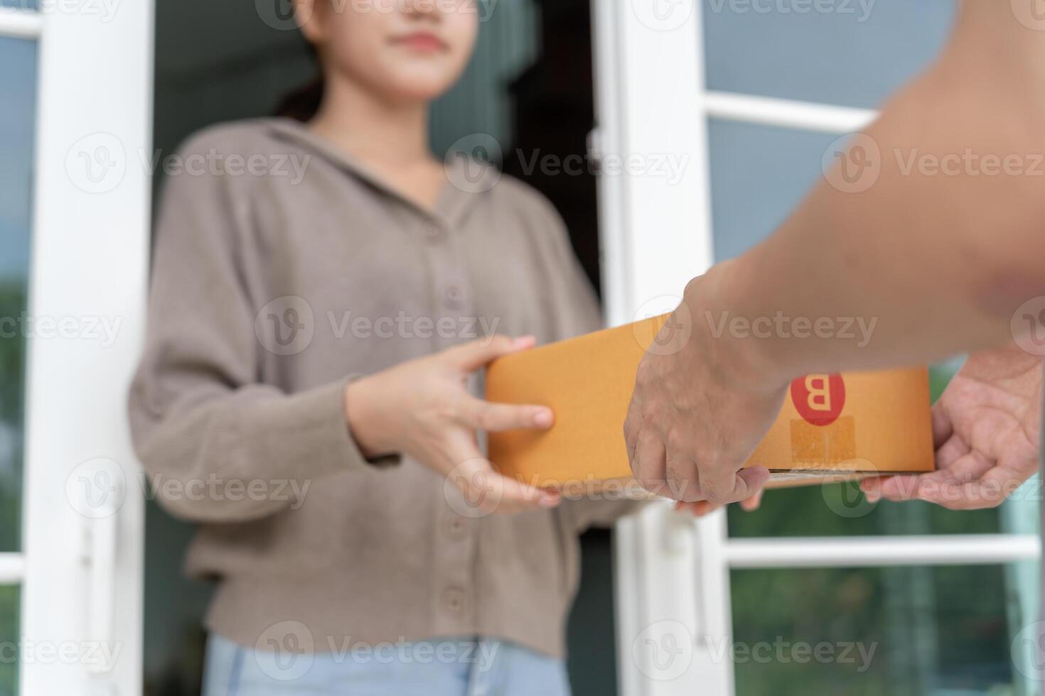 Happy smiling woman receives boxes parcel from courier in front house. Delivery man send deliver express. online shopping, paper containers, takeaway, postman, delivery service packages. photo