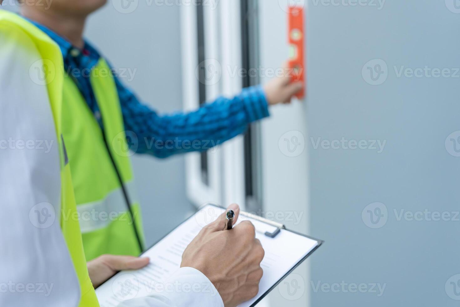 Contactor or engineer inspecting construction and quality assurance new house using a level. Engineers or architects or contactor work to build the house before handing it over to the homeowner photo