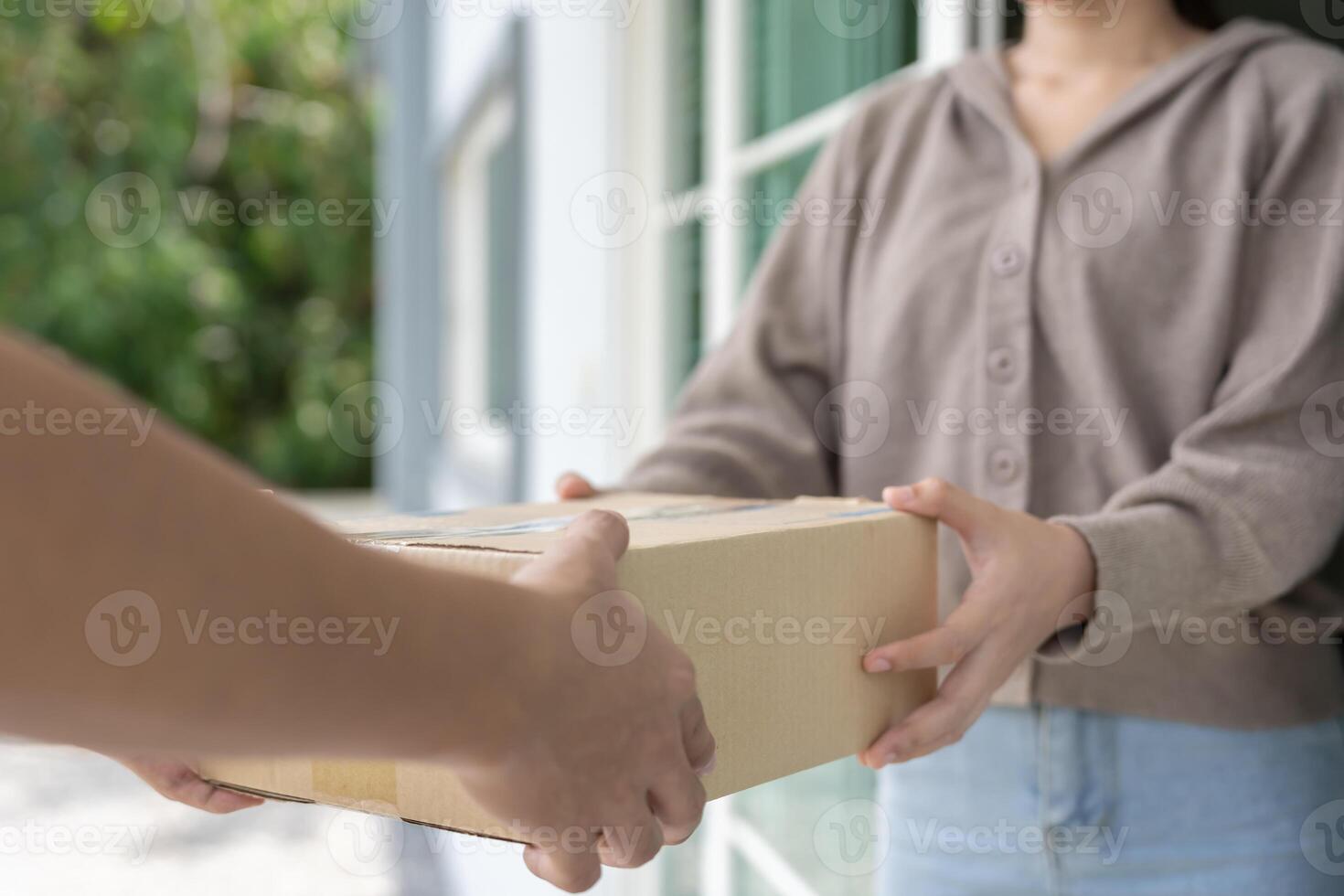 Happy smiling woman receives boxes parcel from courier in front house. Delivery man send deliver express. online shopping, paper containers, takeaway, postman. delivery service. photo