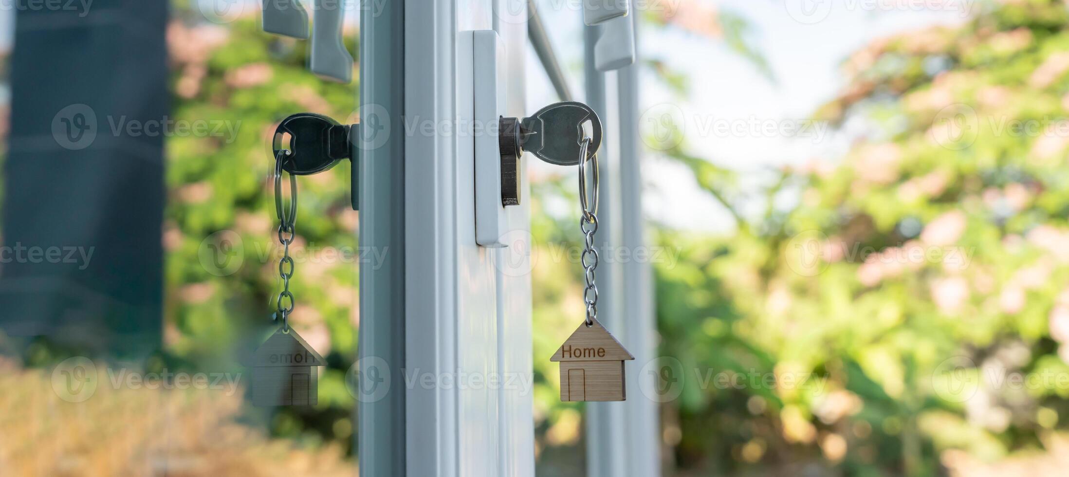 Landlord key for unlock house is plugged into the door. Second hand house for rent and sale. keychain is blowing in the wind. mortgage for new home, buy, sell, renovate, investment, owner, estate. photo