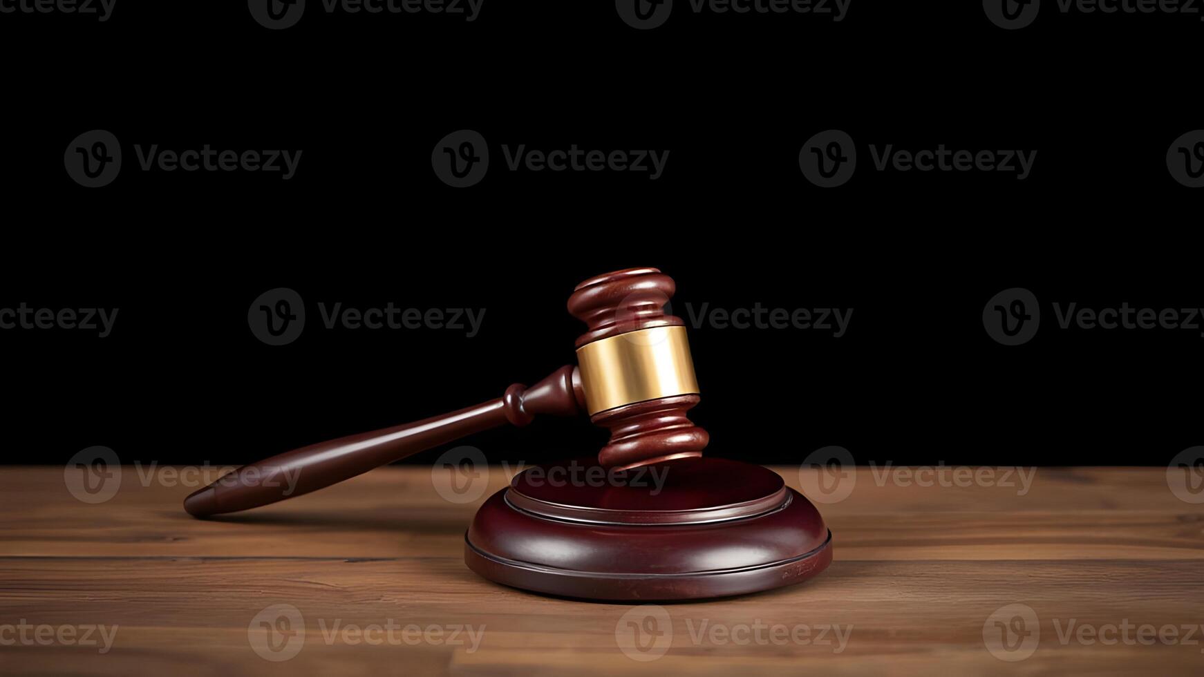 Judge's gavel on wooden table against black background photo