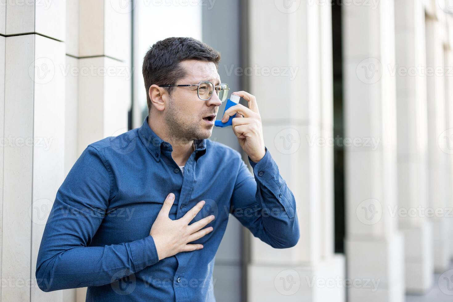 A man uses an inhaler, highlighting respiratory distress and healthcare solutions in an urban setting. photo