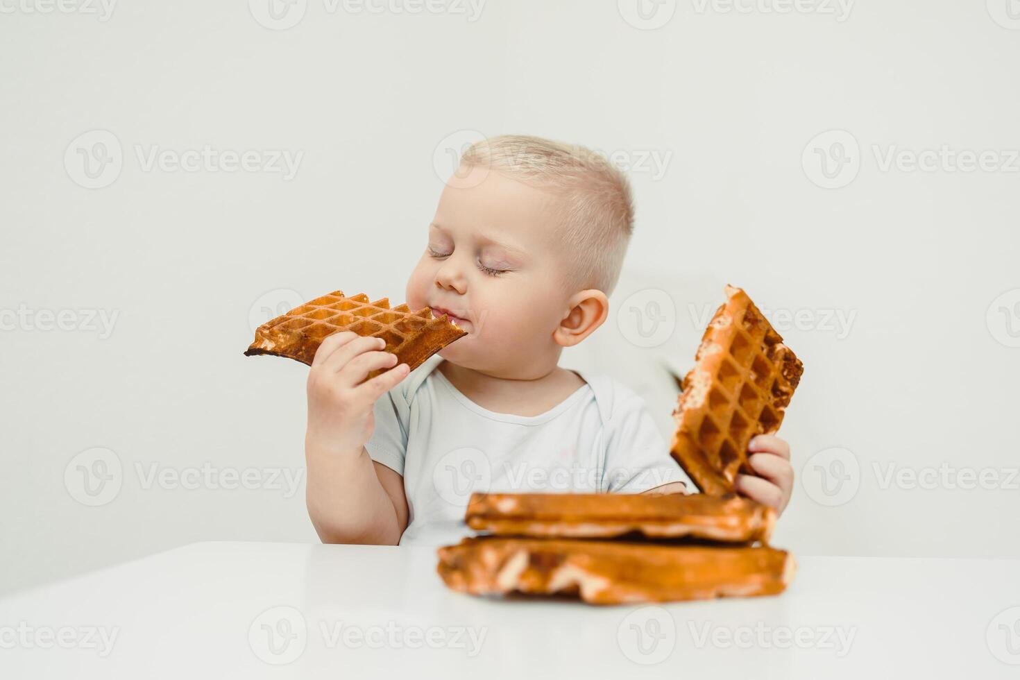A delightful baby is thoroughly enjoying a stack of waffles, creating a sweet moment perfectly captured in time, radiating joy and innocence as they savor every bite of this delicious treat photo
