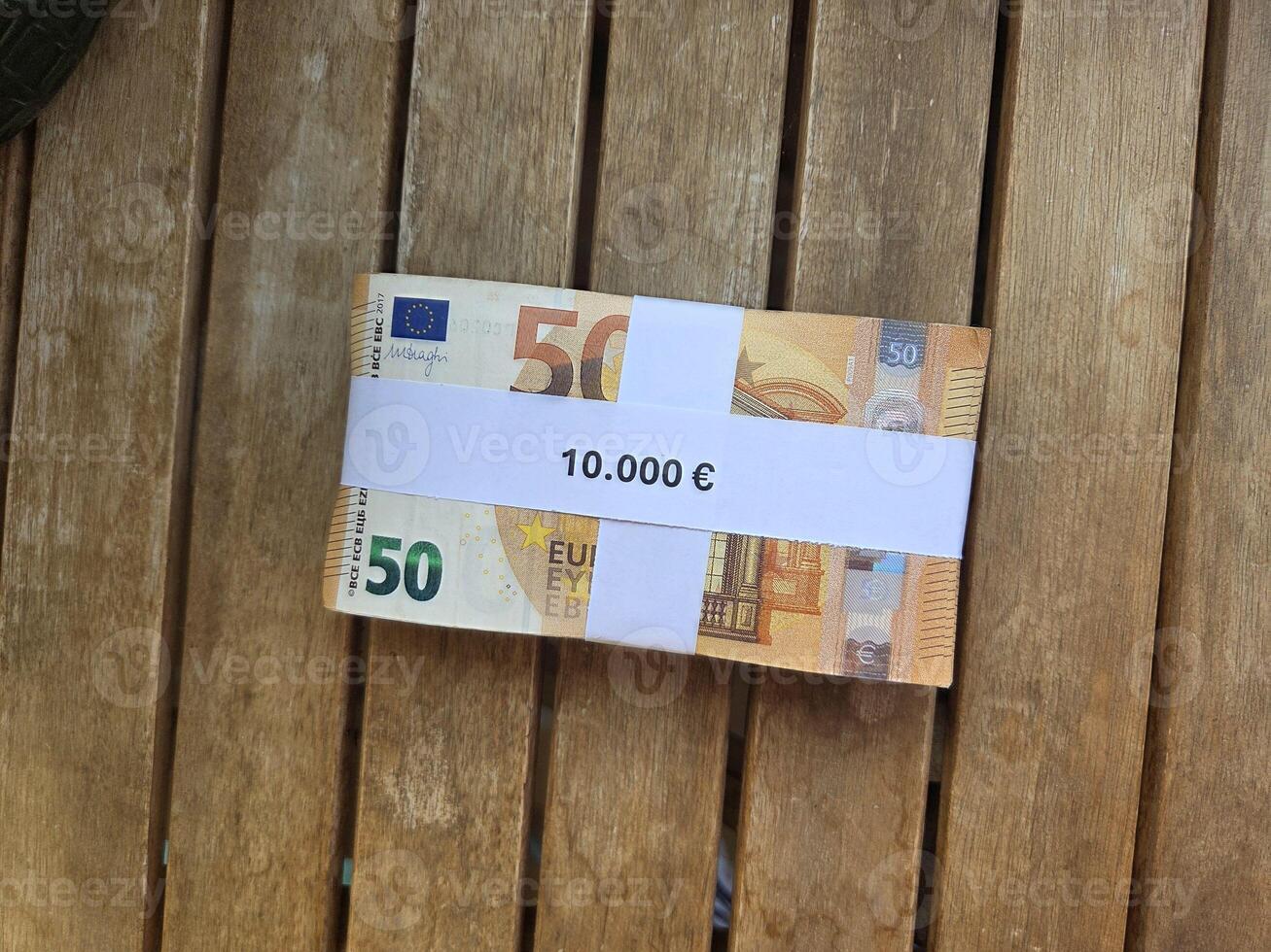 Euro currency bundle on wooden tabletop for financial concept and investment themes. Horizontal banner. Copy space. Money on a wooden background photo