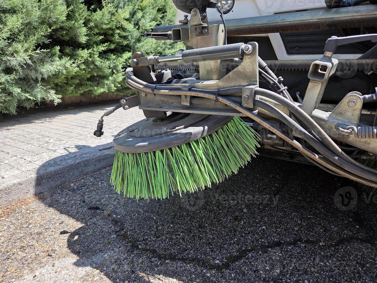 Urban cleanup scene featuring close-up of street sweeper brush in action. A street sweeper or street cleaner photo