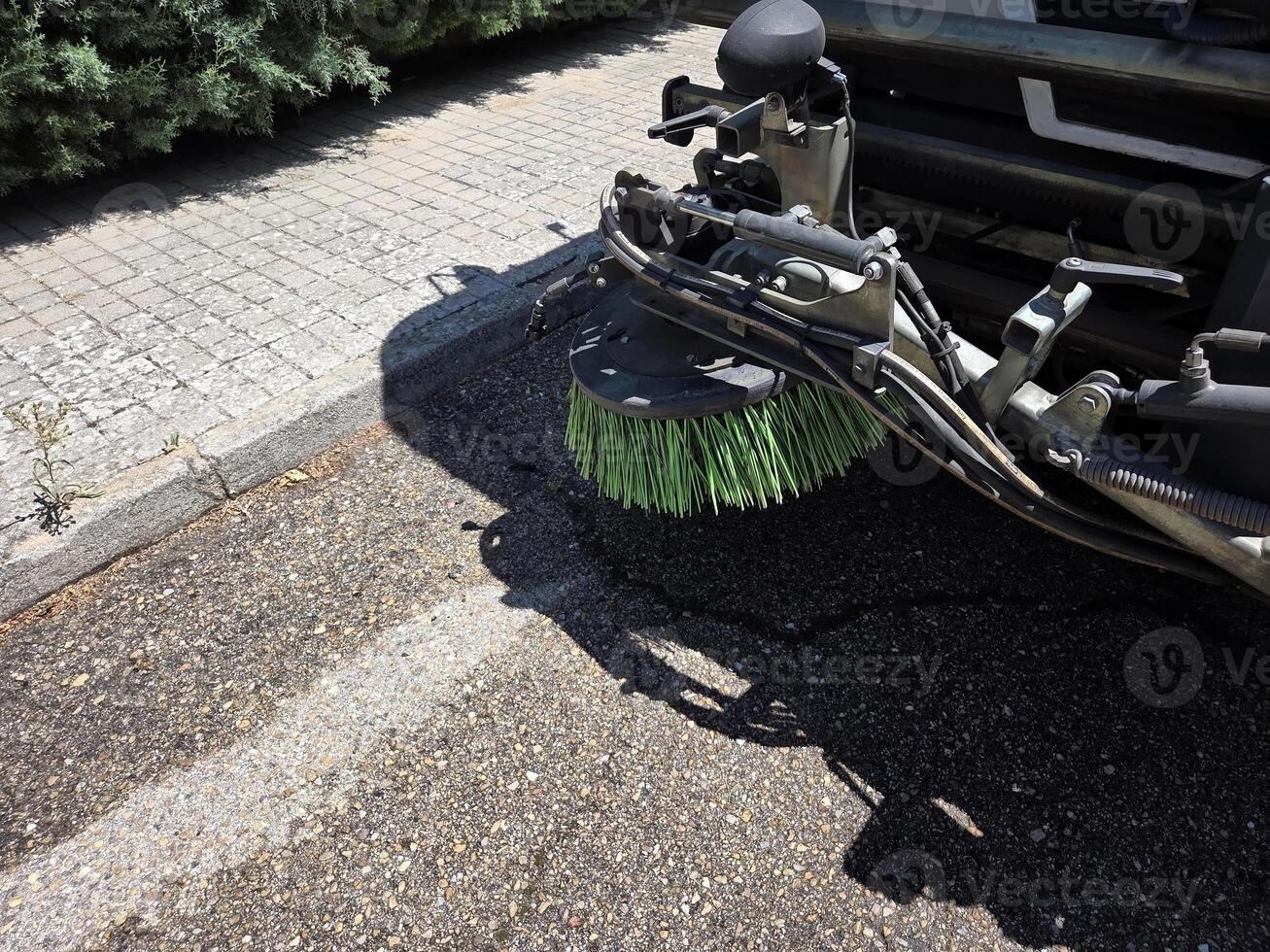 Urban cleanliness concept with street sweeper close-up on pavement. A street sweeper or street cleaner photo
