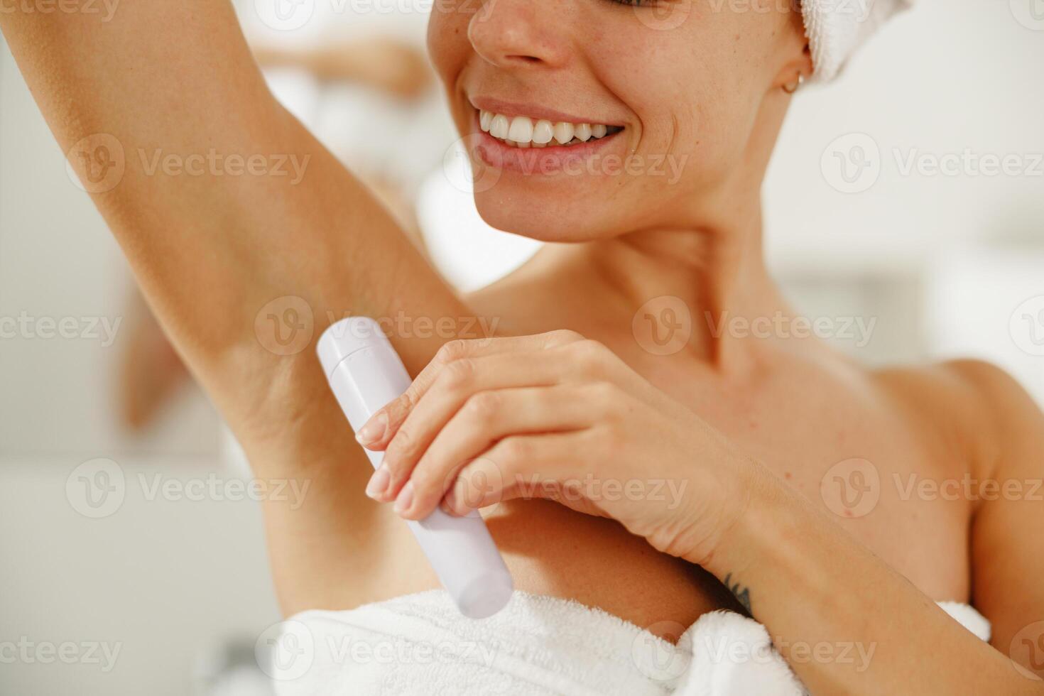 In a stylish bathroom, a woman applies deodorant to stay fresh and confident all day photo