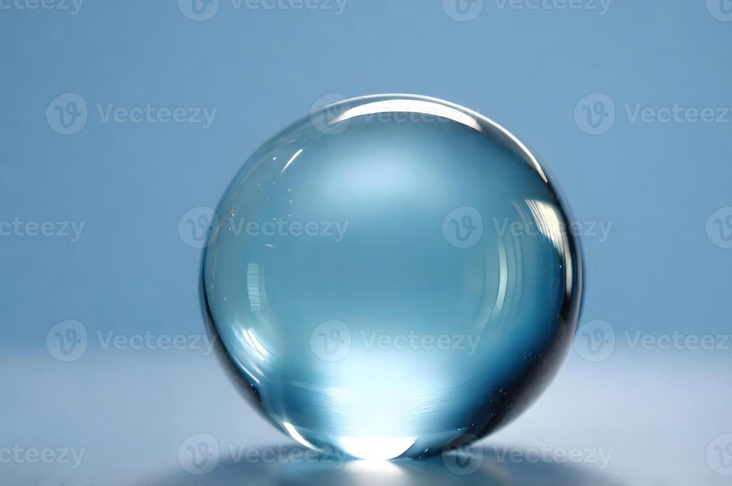Close-up of a Translucent Blue Glass Sphere Against a Light Blue Background photo