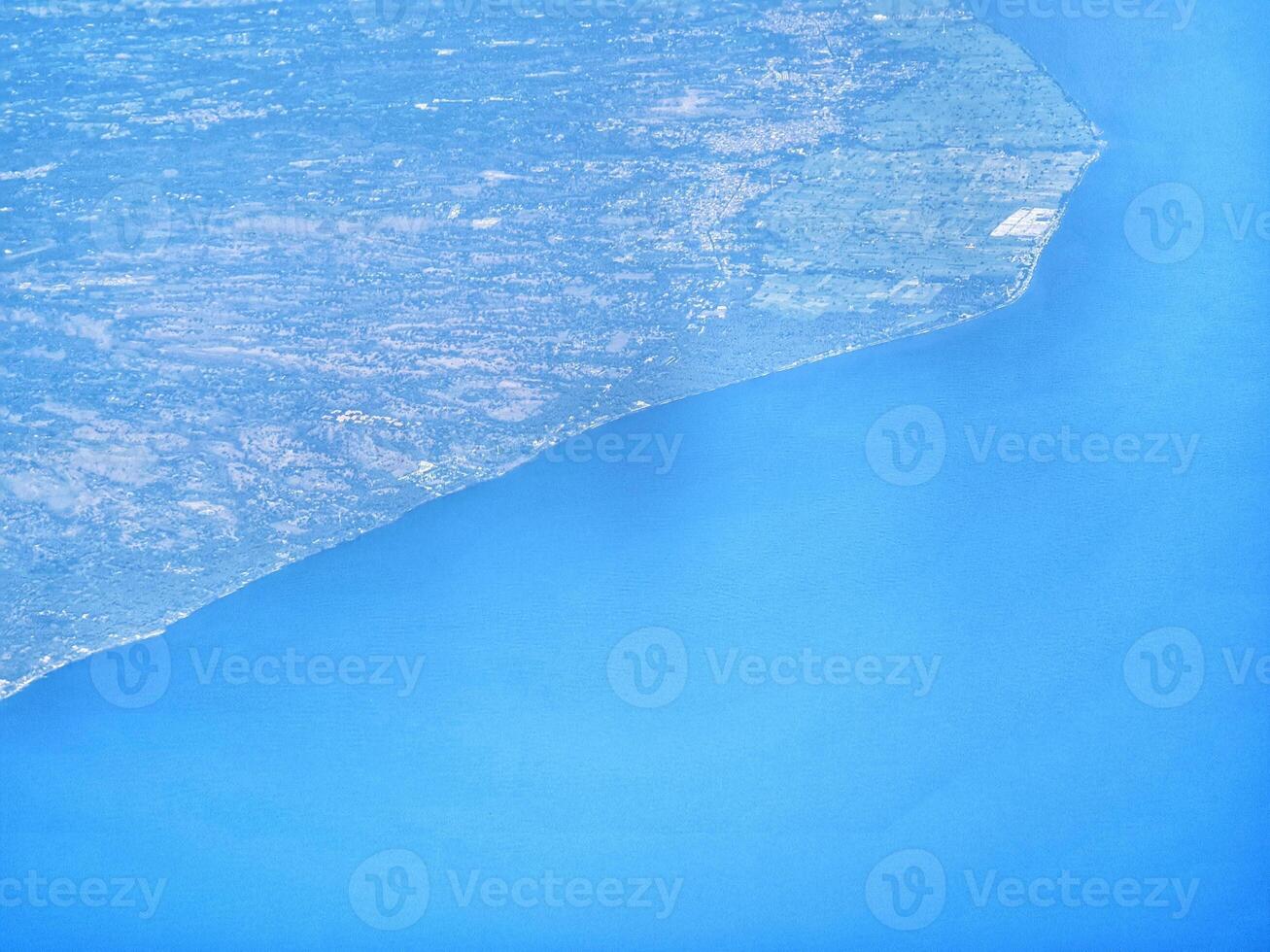 Aerial View of Land Meeting the Sea with Vivid Blue Water photo
