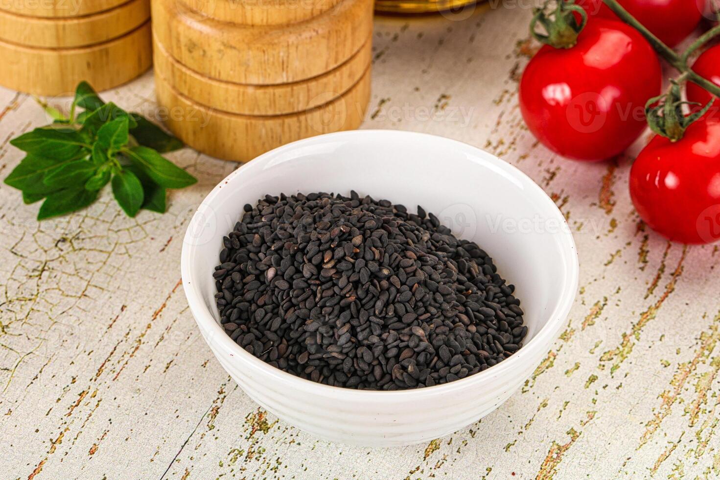 Black sesame seeds in a bowl with tomatoes and spices photo