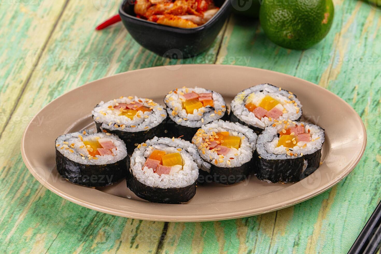 A plate with sushi rolls and other food photo