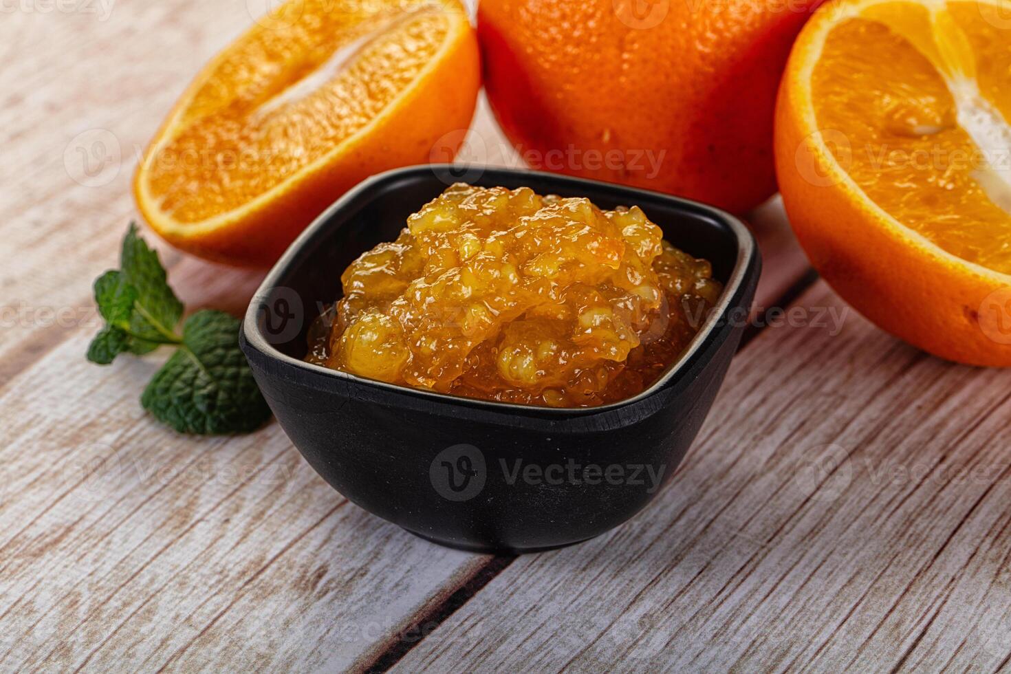 A bowl of fruit on a table next to a half eaten orange photo