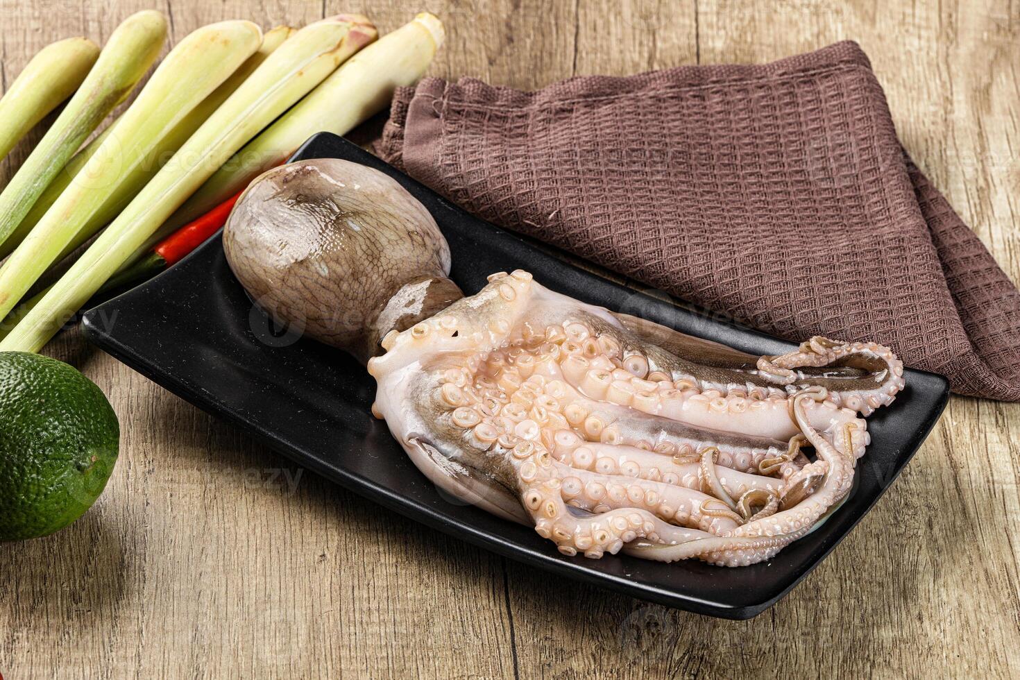 A black plate with an octopus and some vegetables photo
