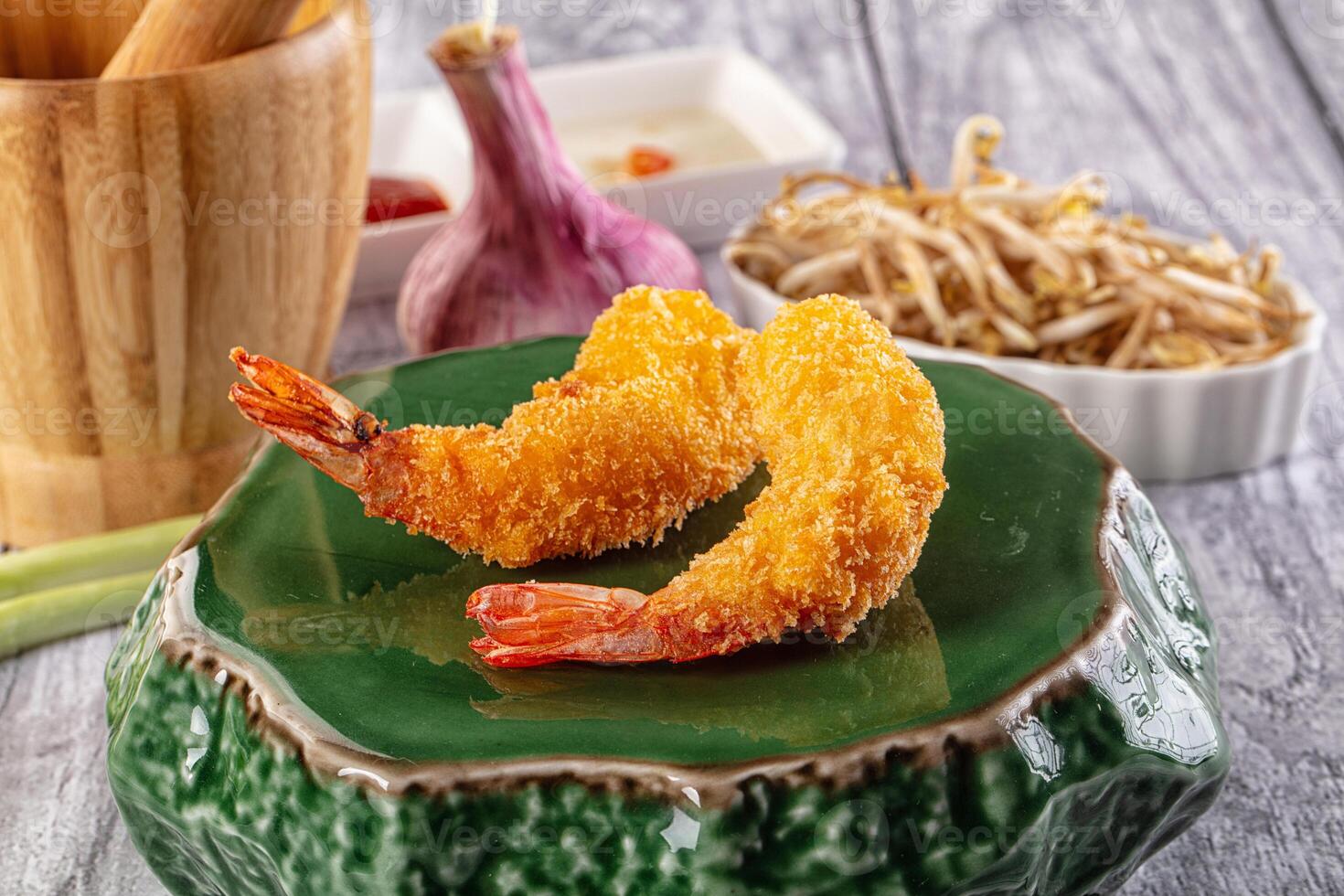 Fried shrimp on a green plate with chopsticks and a bowl of noodles photo