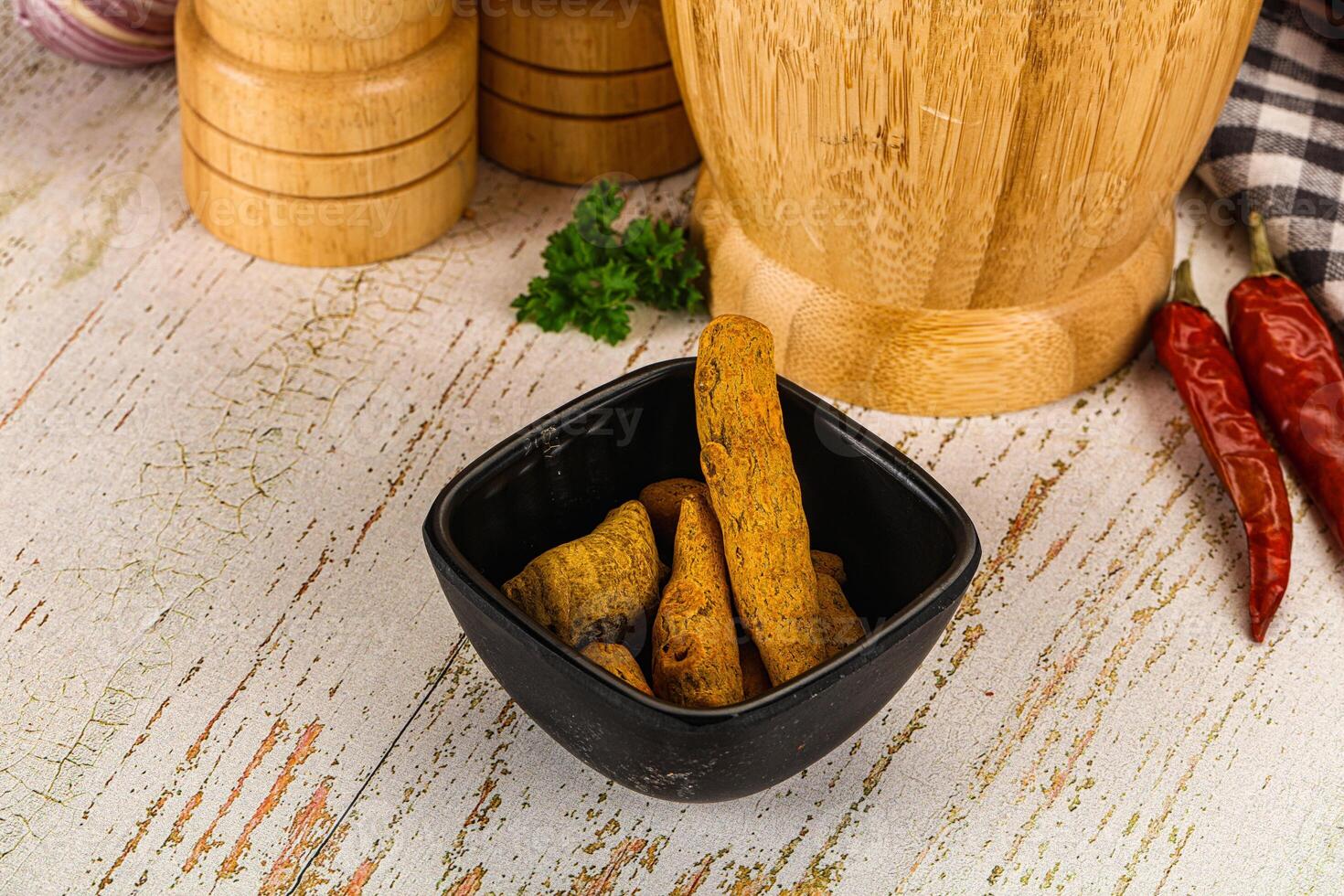 A wooden table with a black bowl of food photo