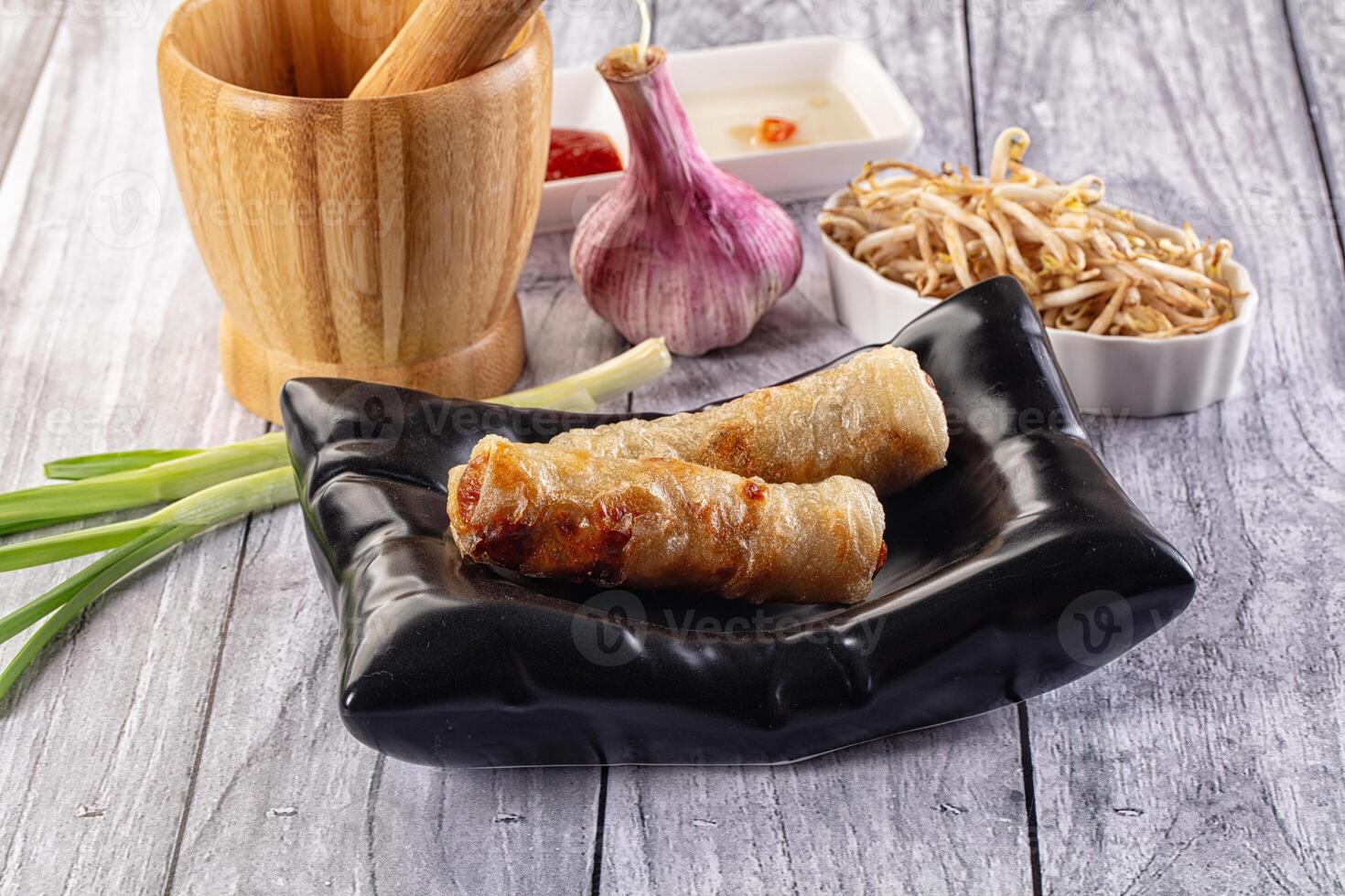 Chinese food on a wooden table with chopsticks and a bowl photo