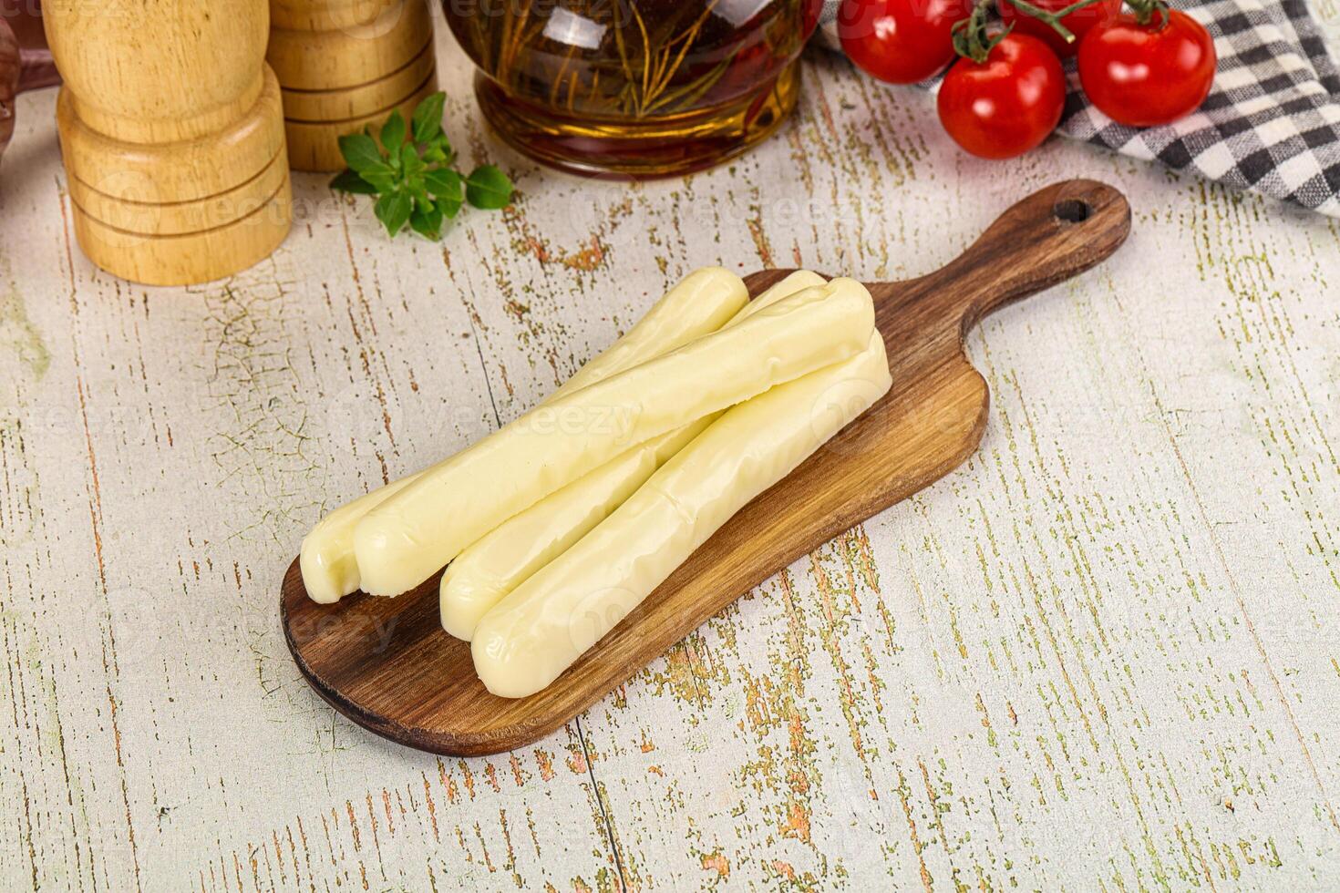 Cheese sticks on a wooden cutting board photo
