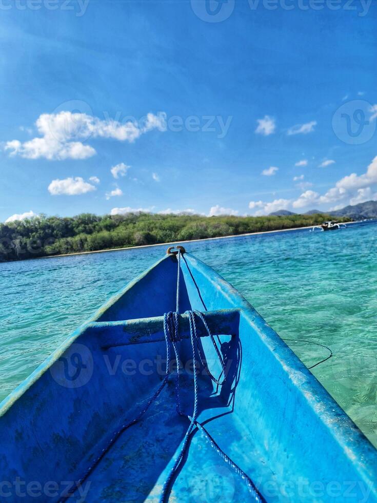 Boating on Clear Turquoise Water Toward Tropical Island on Sunny Day photo