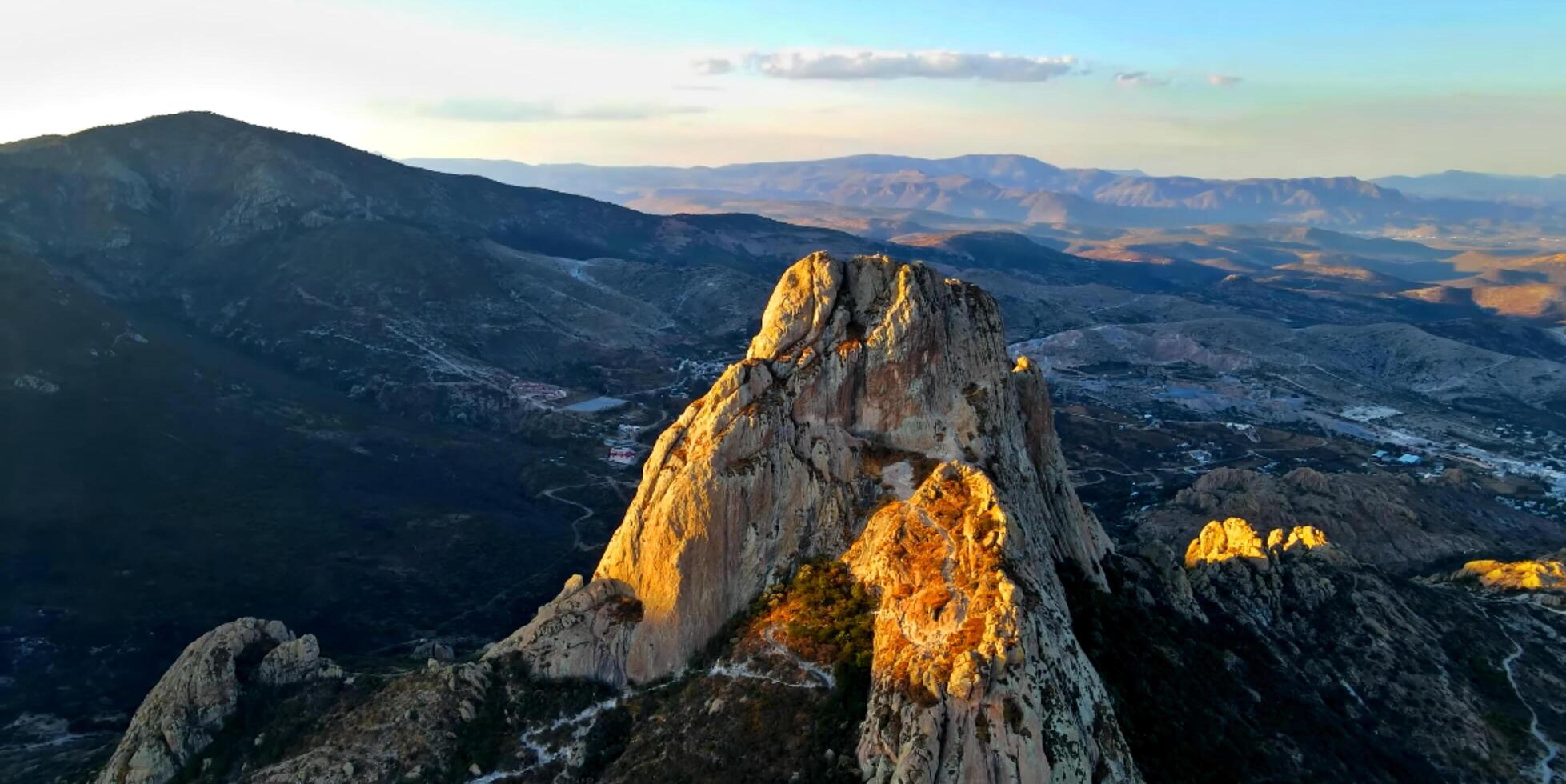 A mountain with a large rock formation in the middle photo