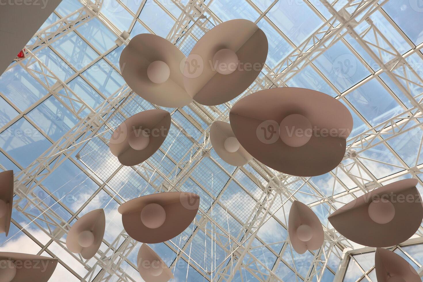 The installation features an artistic ceiling with abstract shapes and a vibrant blue sky photo