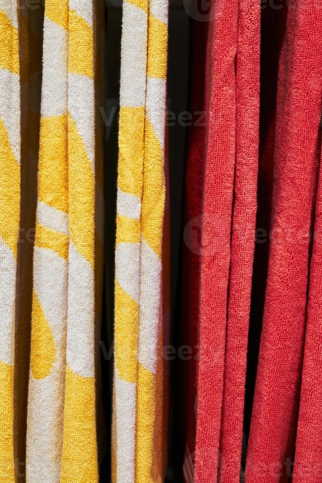 Two towels, one yellow and one red, are hanging side by side. Vertical background, wallpapers. photo