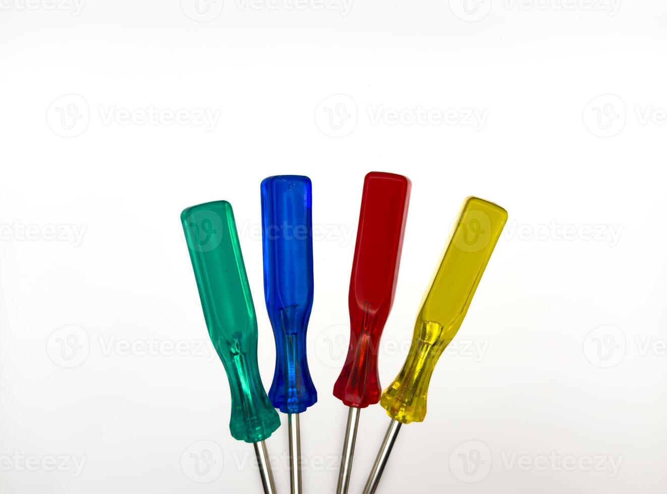 Four small colored plastic screwdrivers on a white background. copy space, flay lay, top view photo