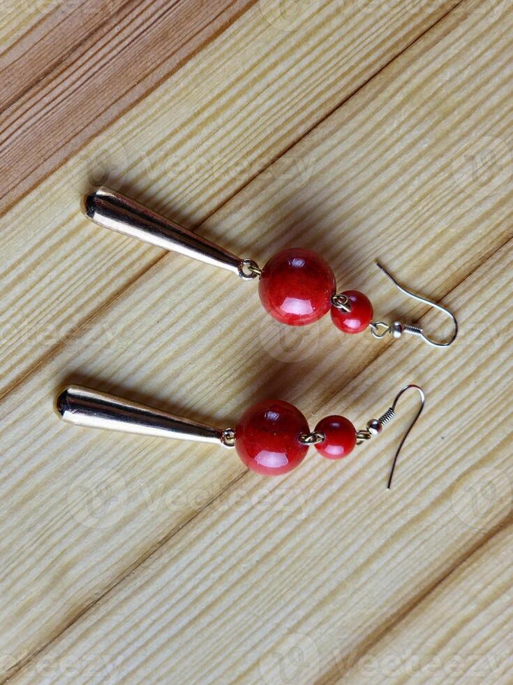 Shiny red coral earrings on wooden background. Close-up. photo