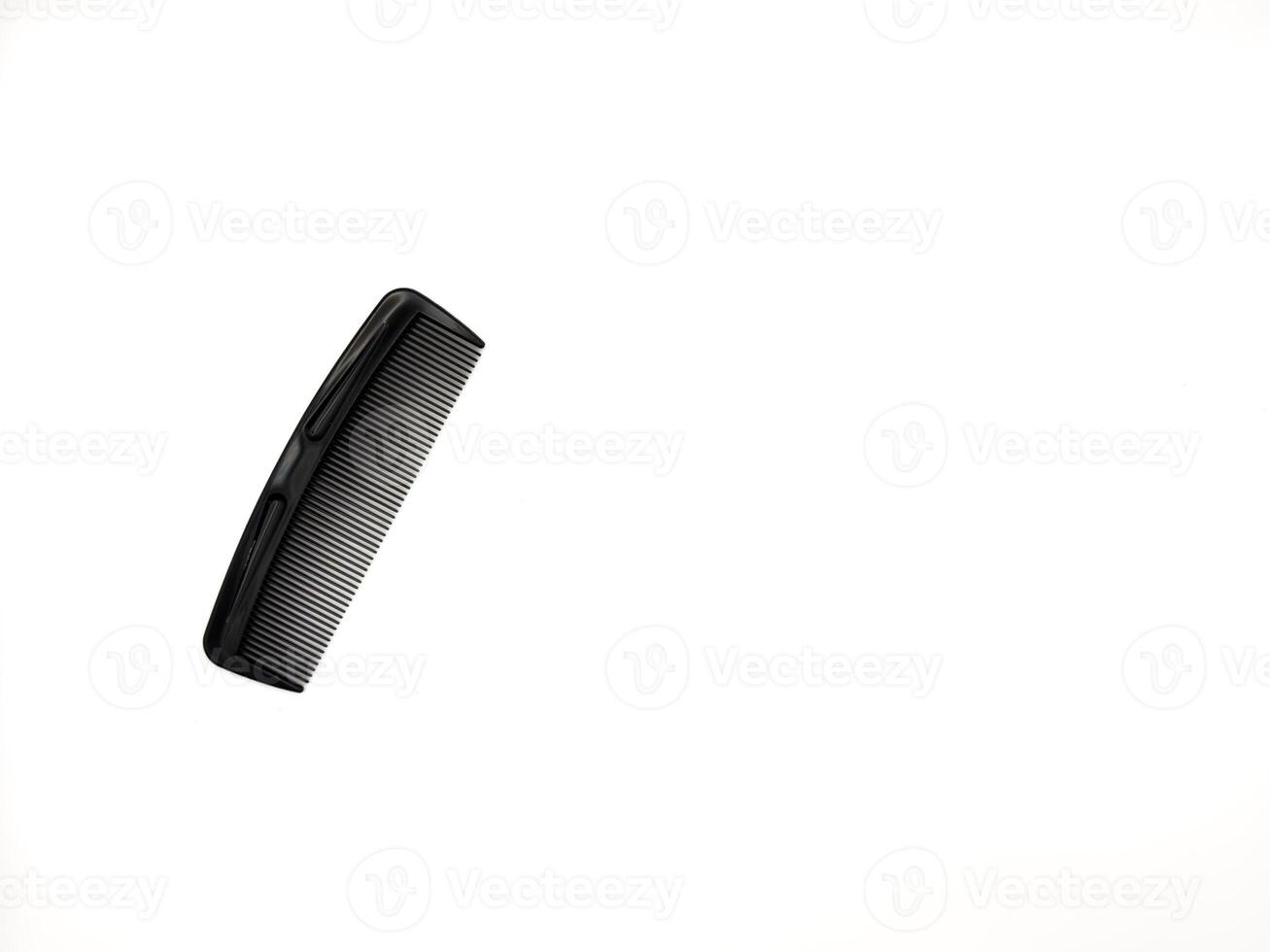 A black comb with a black handle. The comb is laying on a white background, copy space, flay lay, top view, for ads photo