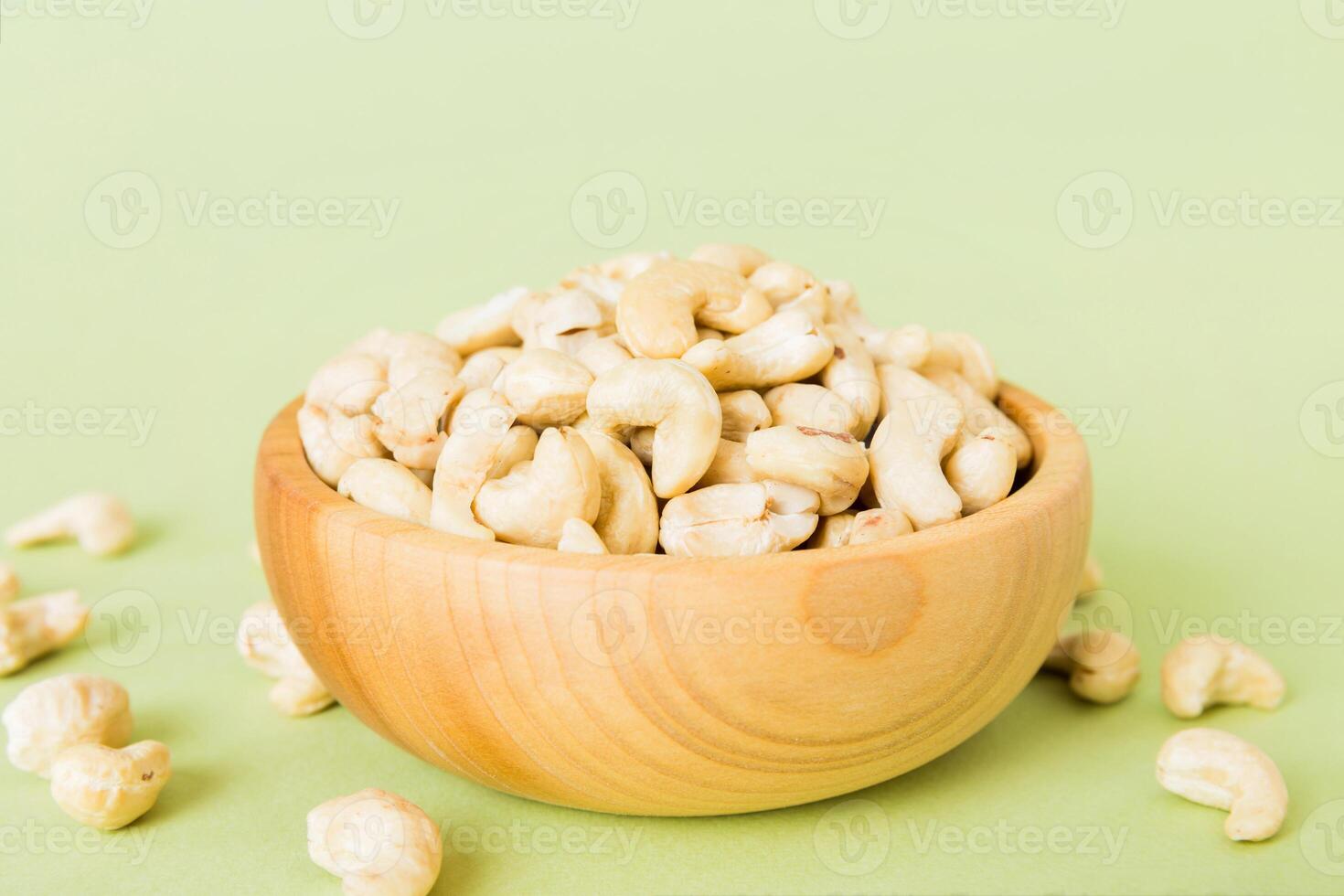 cashew nuts in wooden bowl on table. Space for text Healthy food photo