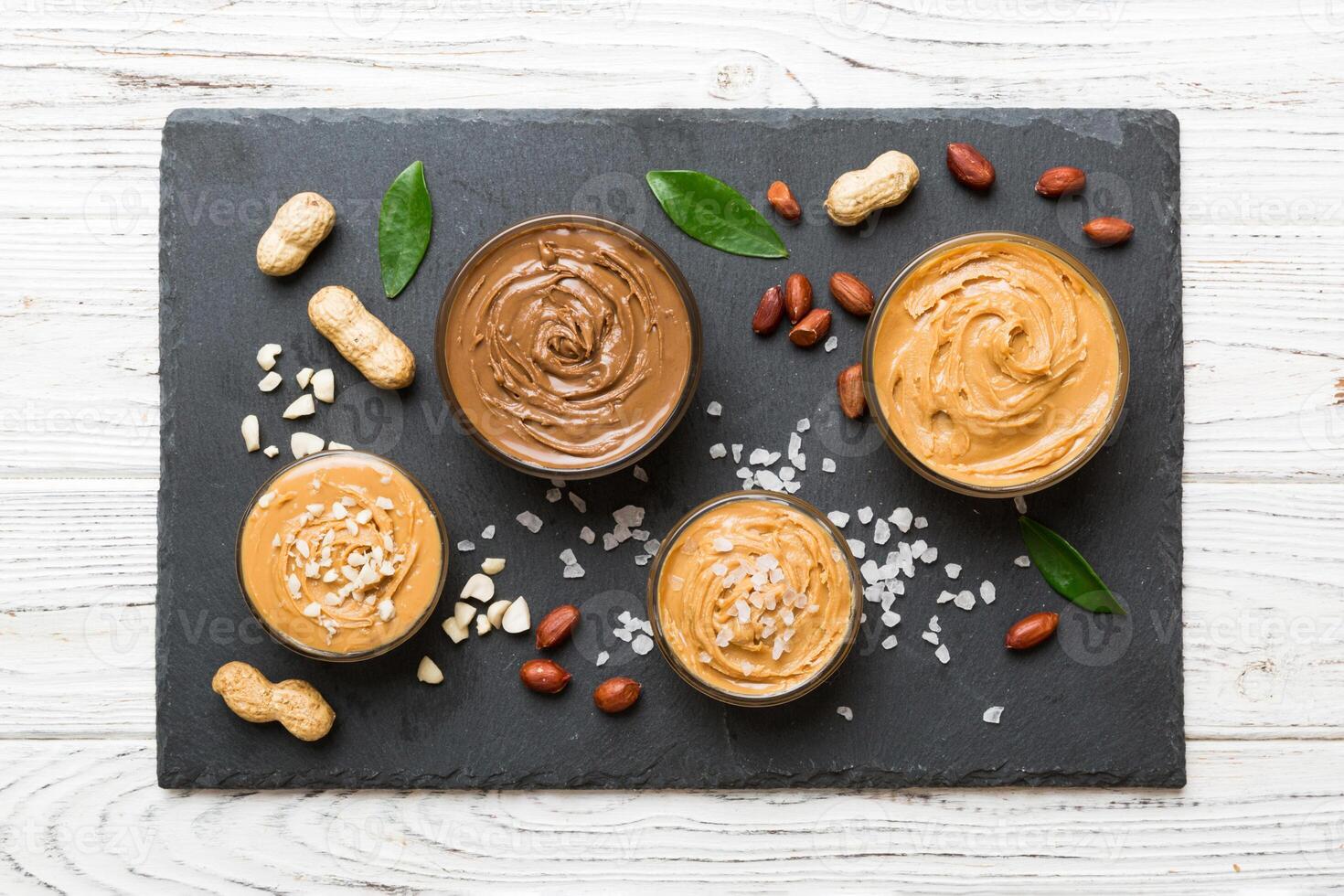 Glass jar with peanut butterin plate on table background, space for text and close up photo