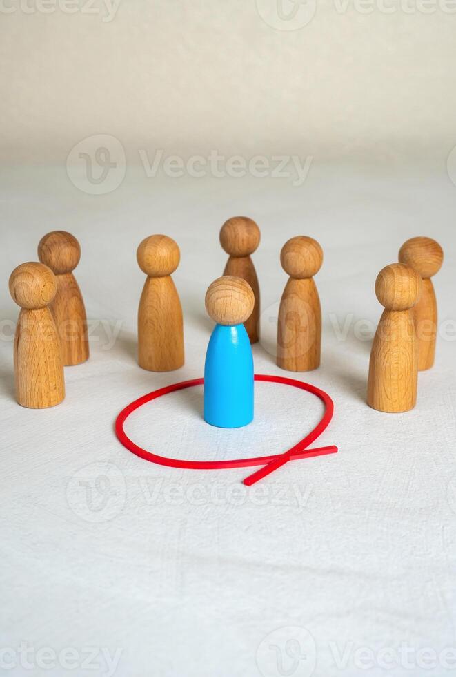 The man is separated from the crowd by a red line. Isolation from society. Safety and personal boundaries. Mental health, introversion, or creating healthy limits. Societal rejection photo