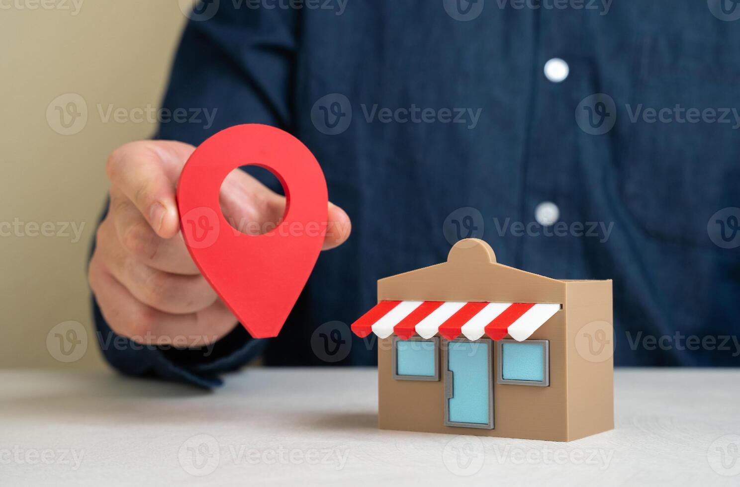 A man holds a geolocation pin near a store. Convenient location and high customer traffic. Business visibility. Role of location in boosting sales, branding, and competitive edge. photo