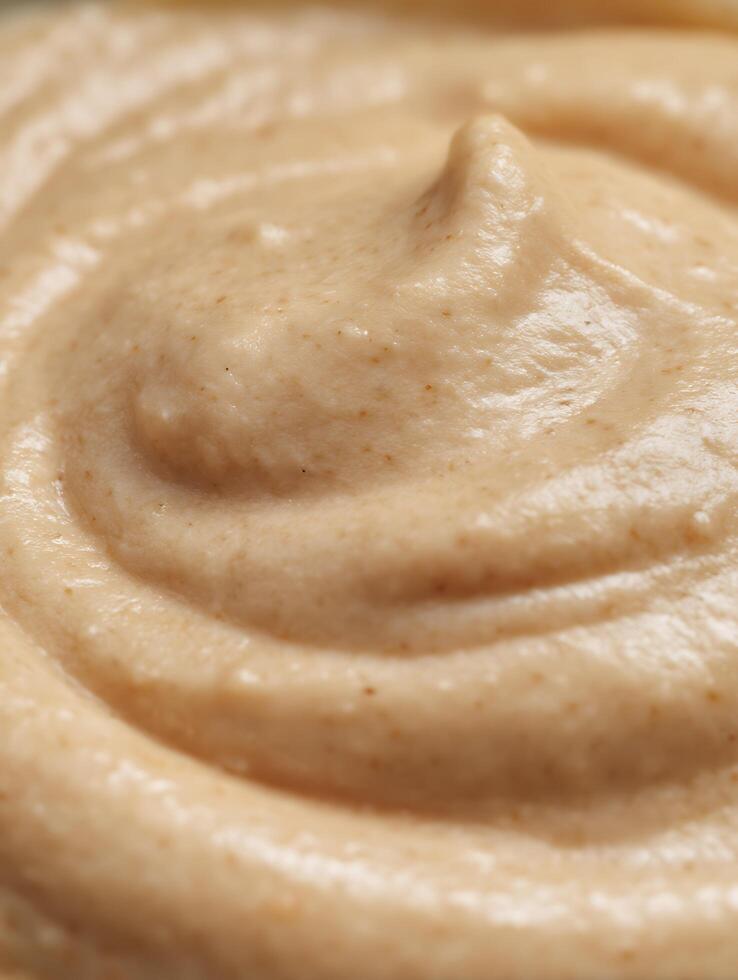 Close up of Creamy Beige Food Texture, Swirled Pattern. photo