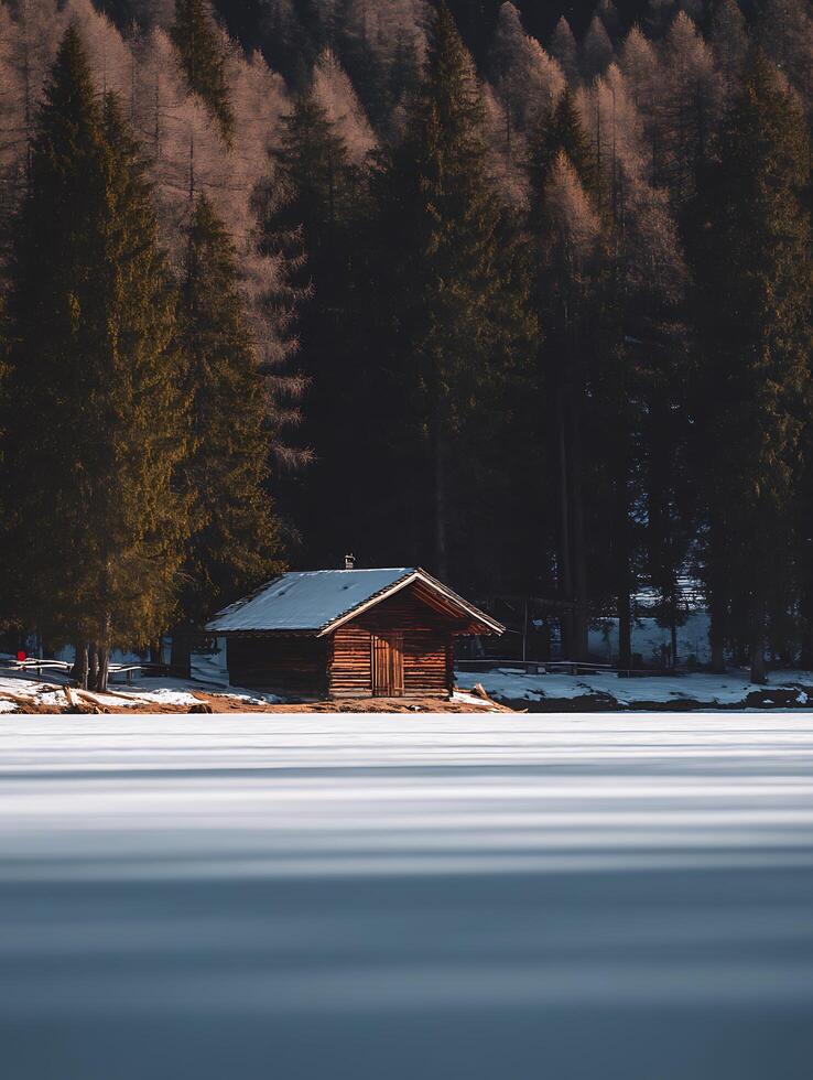 Secluded Wooden Cabin on a Frozen Lake in a Winter Forest. photo