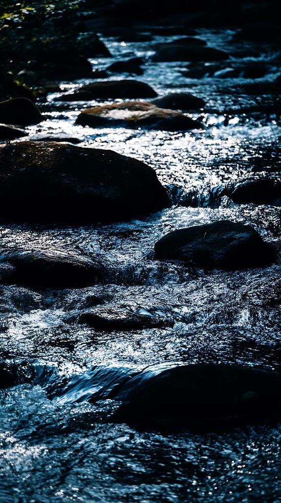 Sparkling River Water Flowing Over Smooth Rocks. A close up view of a stream's movement and texture. photo