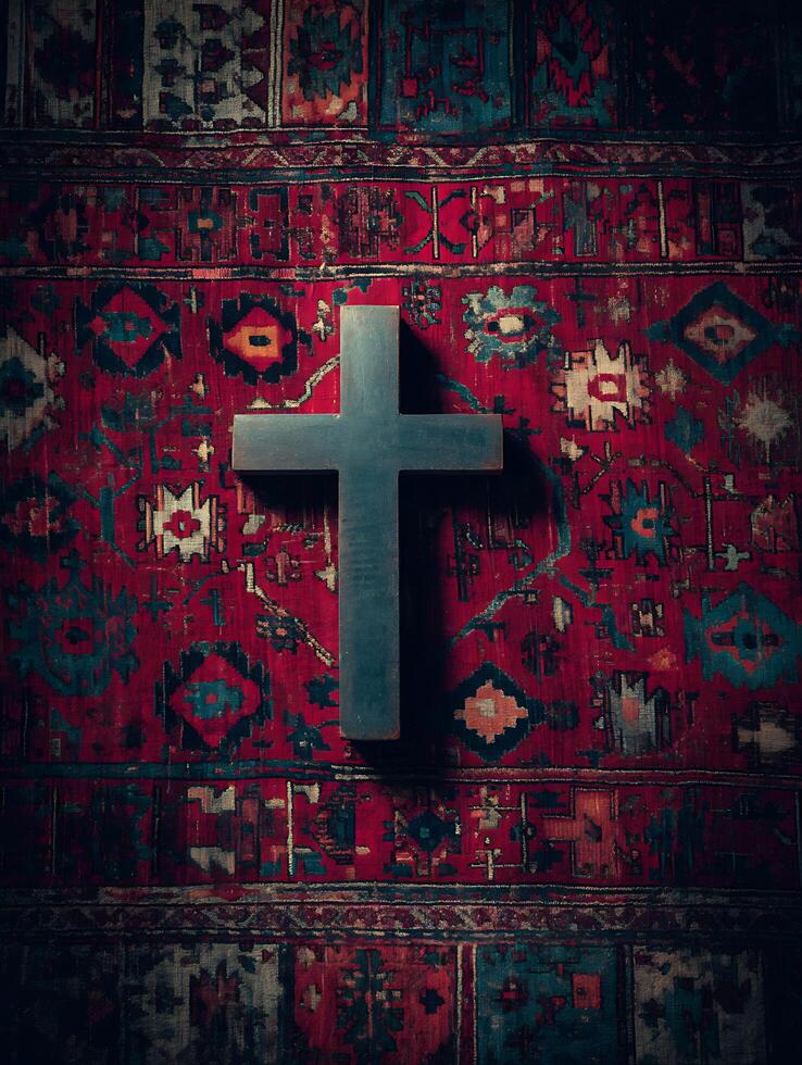 Dark Wooden Cross on Ornate Red Rug A Symbolic Image. photo