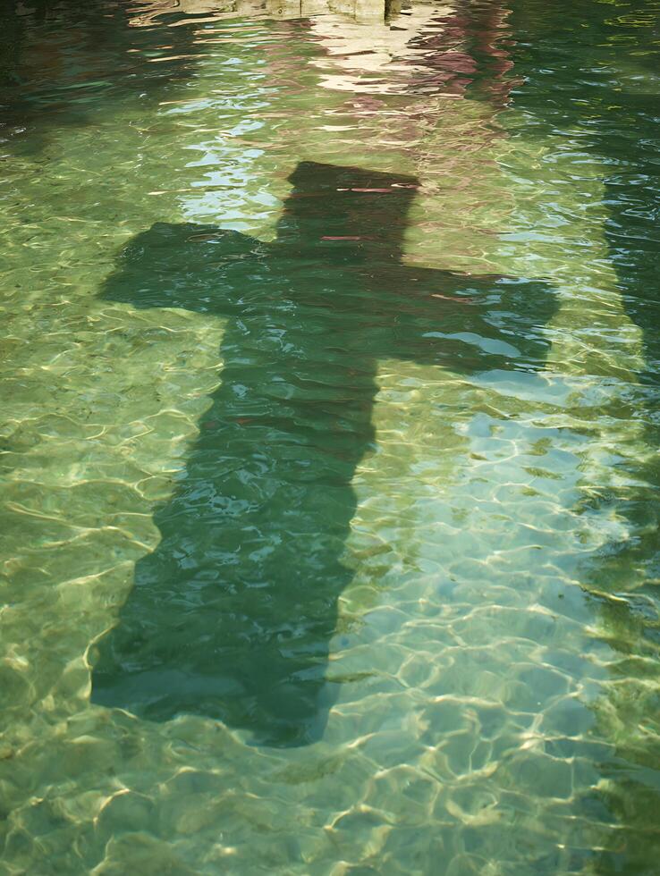 Submerged Cross Shadow in Clear Water A Serene Religious Image. photo