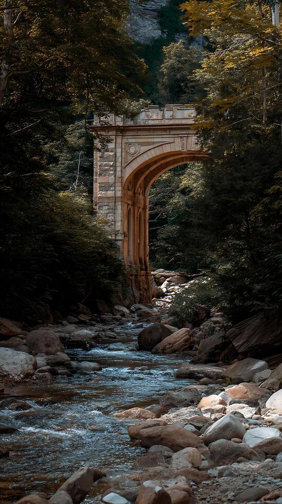 Stone Arch Bridge Over a Rocky Stream in a Lush Forest. photo