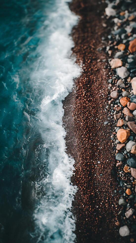 Ocean Wave Meeting Colorful Pebbles on a Shore. A close up view of the meeting point of sea water and a beach. photo