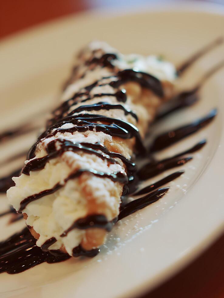 Close up of a delicious cannoli dessert with chocolate sauce and cream filling. photo
