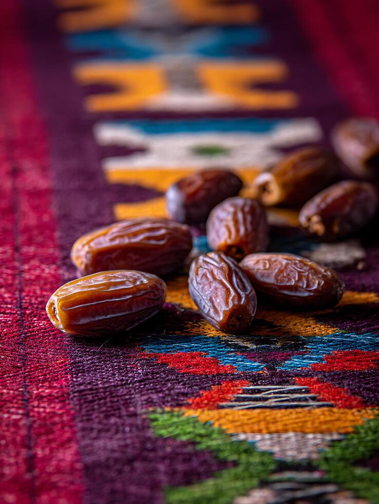Close up of Medjool Dates on a Colorful Rug. A detailed image showcasing the texture and rich color of dates, resting on a vibrant patterned carpet. photo